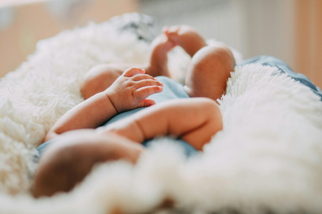 pexels photo 3341189 3341189 A serene close-up of a sleeping newborn lying on a fluffy blanket indoors.